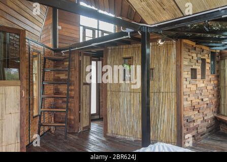 Chambre Design d'intérieur dans un style champêtre avec du bambou et du bois. Chambre design d'intérieur : escalier et des fenêtres et des portes et du lit et lampe. Interior design Banque D'Images