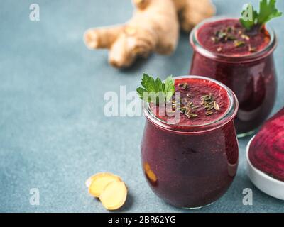 La betterave fraîche et racine de gingembre smoothie. Smoothie de betteraves dans un bocal en verre sur table gris. Shallow DOF. L'espace de copie pour le texte. Manger propre et detox concep Banque D'Images