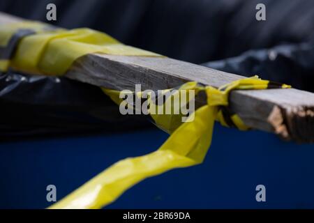 Bande jaune d'avertissement lié à un morceau de bois dans une poubelle Banque D'Images