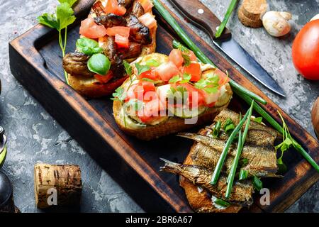 Assortiment de bruschetta avec garnitures diverses.L'Italien bruschetta sur planche à découper en bois Banque D'Images