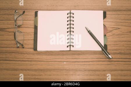 Bureau avec Ouvrez le bloc-notes, un stylo, lunettes, bien placé sur la table du Bureau. Vue de dessus avec l'exemplaire de l'espace. Concept d'affaires vie encore avec office trucs sur ta Banque D'Images