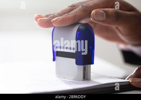 Close-up of Businesswoman Putting Stamp sur Documents dans le bureau Banque D'Images