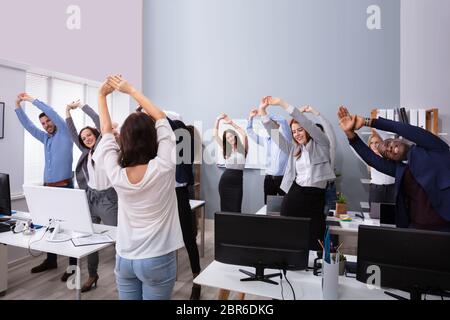 Professionnels Multi-ethnic Businesspeople Sensibilisation Exercice s'étendant dans les mains faisant office de tourisme Banque D'Images