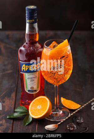 LONDRES, Royaume-Uni - 20 MAI 2020 : bouteille de cocktail apéritif apéritif apéritif apéritif avec verre et oranges d'origine avec cuillère de bar sur fond de table en bois. Banque D'Images