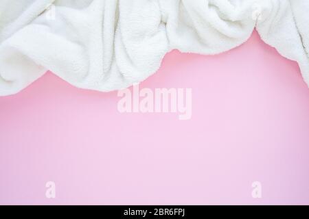 Vue de dessus tissu écossais blanc sur fond rose avec motif copie. Concept de pose à plat confortable Banque D'Images