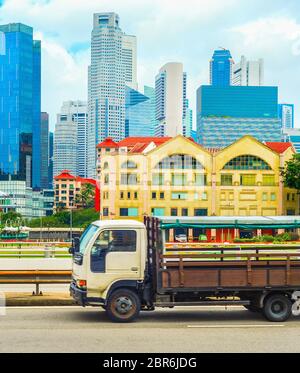Chariot sur une route passant par le centre-ville de Singapour ville avec des gratte-ciel de l'architecture moderne Banque D'Images
