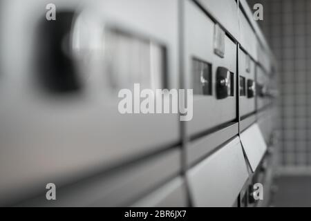 Gros plan extrême de boîte aux lettres métalliques modernes dans un condominium. Arrière-plan flou flou artistique. Banque D'Images