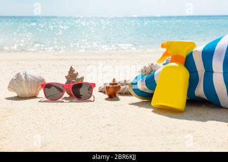 Lunettes de soleil, crème solaire, de coquillage et de sacs à main On Beach Banque D'Images