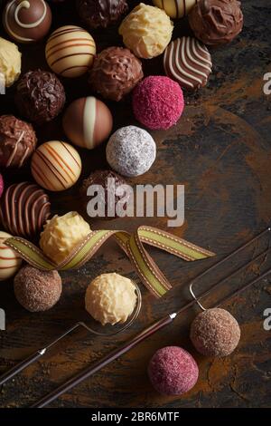 Sélection de boules de chocolat Pralines ou en rangées sur vintage rustique en bois avec fourche de l'élévateur et fils Banque D'Images