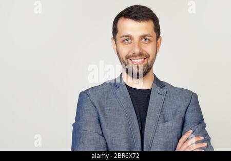 Portrait d'un jeune entrepreneur masculin souriant largement avec une expression confiante d'elle-même, homme d'affaires souriant avec les bras croisés. Gros plan sur un homme d'affaires heureux et réussi. Banque D'Images