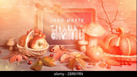 Texte « Zero Waste Thanksgiving » sur tableau noir. Décorations traditionnelles d'automne, image panoramique teintée. Feuilles d'automne, baies, champignons, citrouilles, fleurs Banque D'Images