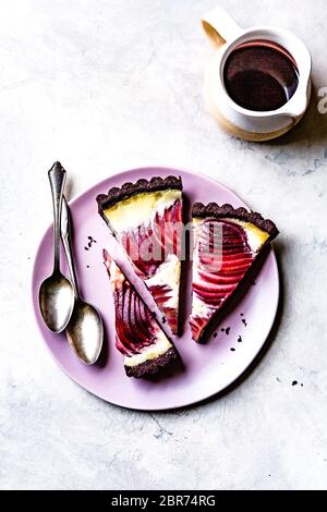 Tarte à la crème de poire pochée au vin rouge sur une assiette. Banque D'Images