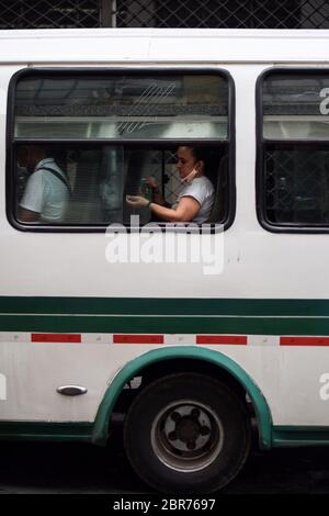 Une femme désinfecte les mains dans un autobus public pendant l'épidémie de coronavirus en Colombie Banque D'Images