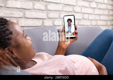 Close-up of pregnant woman Video appelant son médecin sur Mobilephone Banque D'Images