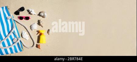 Les coquillages, lunettes de soleil, crème solaire et Bouteille Sac à Sand At Beach Banque D'Images