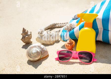 Lunettes de soleil, crème solaire, de coquillage et de sacs à main On Beach Banque D'Images