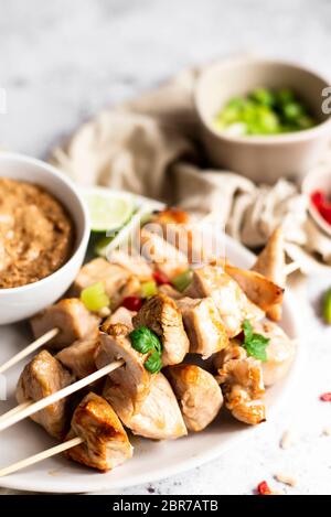 Brochettes de poulet avec sauce satay et oignons de printemps et piments Banque D'Images