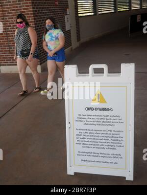Un panneau d'avertissement COVID-19 est visible à Disney Springs à Walt Disney World le jour où le complexe de vente au détail, de restauration et de divertissement commence à rouvrir progressivement après la fermeture du parc thématique le 16 mars 2020 en raison de la pandémie du coronavirus. Tous les visiteurs de Disney Springs devront porter des revêtements de visage et les soumettre aux contrôles de température. Banque D'Images