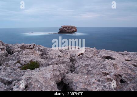 Rochers et phare de Porto colom, Europe, Espagne, Iles Baléares, Majorque. Porto Colom. Promenade le long du bord de mer. phare. Banque D'Images