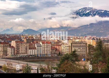 Scenic Vue aérienne de les rives de la rivière Isère, pont, les toits et les Alpes françaises sur l'arrière-plan, Grenoble, France Banque D'Images