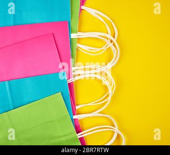 Multi-couleur rectangulaire des sacs en papier avec poignées blanc sur fond jaune, télévision lay Banque D'Images