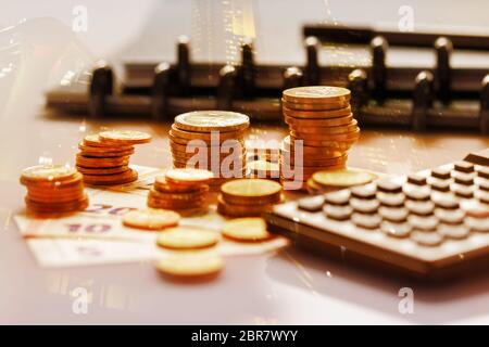 Pièces en euros en pile sur les billets en euros avec calculatrice, pour les fonds. Allemagne Banque D'Images