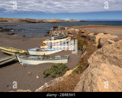 Petits, anciens bateaux de pêche en bois, peintes de couleurs vives, sont situés sur le Volcanicsand noir-plage juste en face de l'océan Atlantique dans le village un Banque D'Images