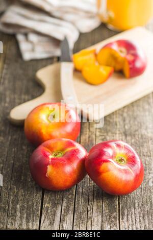 Nectarines plates mûres sur une ancienne table en bois. Banque D'Images