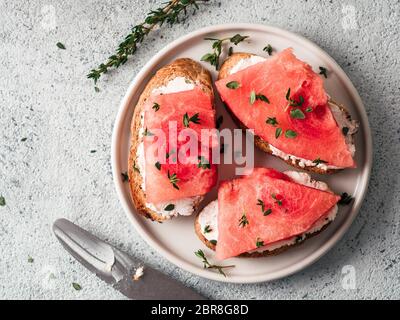 Toasts avec du fromage à pâte molle et de pastèque.salé sucré,fromage épicé et de pastèque grillés croustillants sur thym tranches de pain.Idée et recette pour la santé inhabituel Banque D'Images