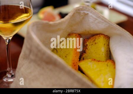 Panier de produites et un verre de vin blanc sur une table de dîner Croate Banque D'Images