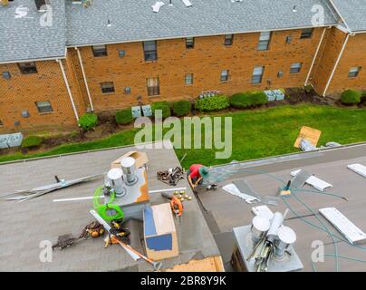 Couvreur travaillant sur la construction de toit de bardeaux d'asphalte de remplacement Banque D'Images