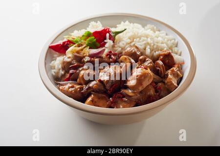 Chaque bol de riz blanc cuit sauce épicée et couverts cubes de viande sur fond blanc froissé Banque D'Images