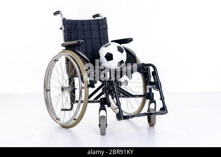 fauteuil roulant avec ballon devant un fond blanc Banque D'Images