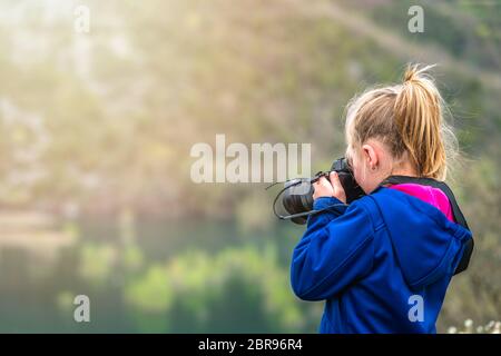 Cute little woman prendre des photographies de la faune dans le parc à l'extérieur Banque D'Images