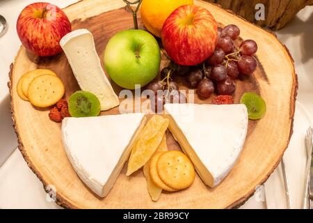 Fromage brie avec grande variété de fruits et de craquelins sur plaque de bois en ligne buffet Banque D'Images