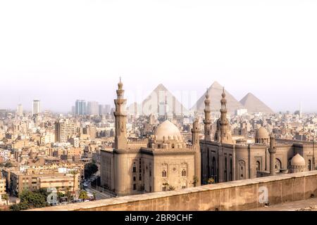 Vue sur le Mosque-Madrassa du Sultan Hassan au Caire et les pyramides de Gizeh, Egypte. Banque D'Images