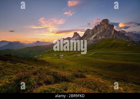 Vue sur le coucher du soleil en été sur le Passo di Giau avec mont Ra Gusela sur le contexte et les rhododendrons sur le premier plan, Colle Santa Lucia, Dolomites, Italie Banque D'Images