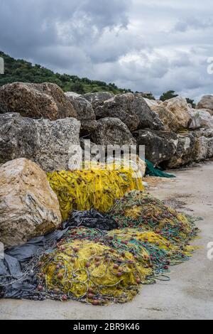 Filets de pêche pêcheur jaune emmêlées abandonnés et empilés sur la rive de l'île de Zante, Grèce Banque D'Images