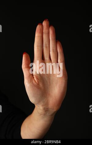 Main femme montrant palm sur fond noir d'arrêt, side view Banque D'Images