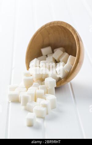 Cubes de sucre blanc doux en bol en bois. Banque D'Images