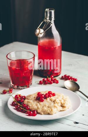 Simple et petit-déjeuner sain avec de porridge et de l'eau infusée aux fruits rouges Banque D'Images