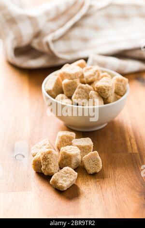 Brown Sugar cubes sur table en bois. Banque D'Images