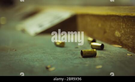 Balle de pistolet vide sur une table en bois dans un champ de tir. Extreme close up et selective focus avec arrière-plan flou. Banque D'Images