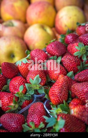 De délicieuses pommes biologiques et rouge et à parfaite maturité des fraises en vente sur un marché de producteurs Banque D'Images