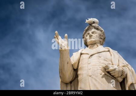 Oiseau blanc assis sur le dessus de l'ancienne statue de Dionysios Solomos dans Zakythos Town Square, Grèce Banque D'Images