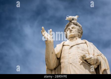 Oiseau blanc assis sur le dessus de l'ancienne statue de Dionysios Solomos dans Zakythos Town Square, Grèce Banque D'Images