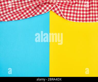 Rouge à carreaux blancs sur une serviette de cuisine fond jaune bleu lumineux, arrière-plan, pique-nique copy space Banque D'Images