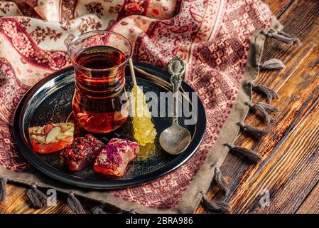 Plateau en verre armudu avec délice oriental rahat lokum sur le plateau métallique sur la surface en bois et cirée Banque D'Images