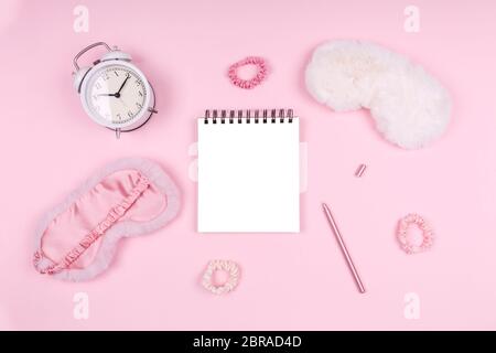 Bloc-notes avec des masques de sommeil moelleux et des accessoires roses. Gestion et optimisation du sommeil, concept de sommeil et de journal de sommeil de beauté. Placer pour le texte Banque D'Images