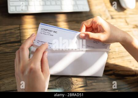 Close-up de l'homme d'affaires d'ouverture de l'enveloppe avec un chèque en bois de plus de 24 Banque D'Images